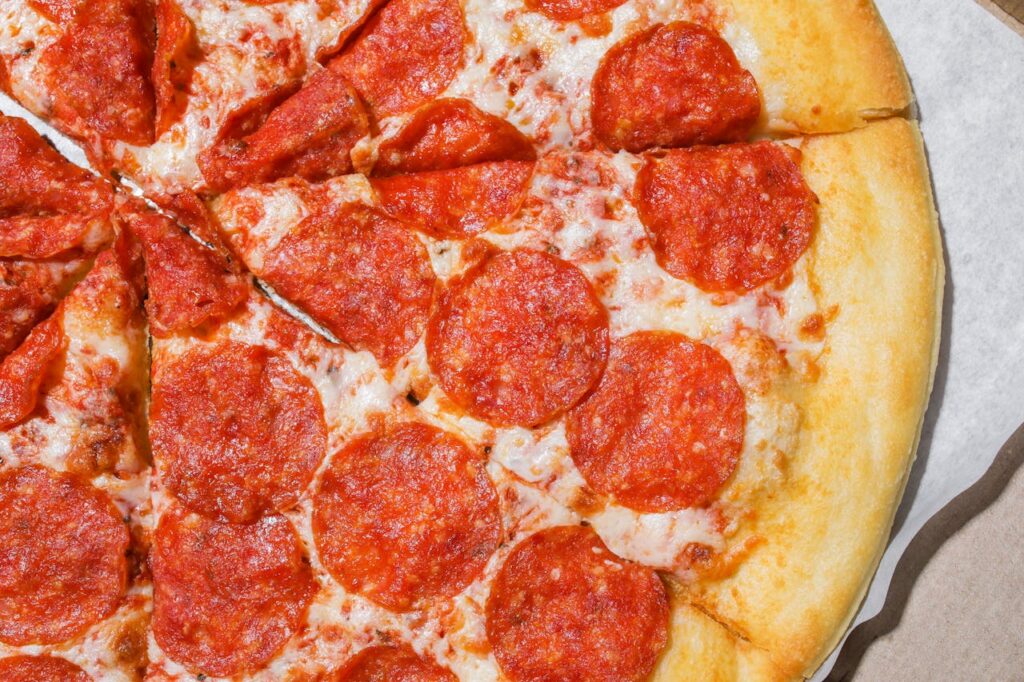 Mouthwatering close-up of pepperoni pizza slices with melted cheese and crispy crust.