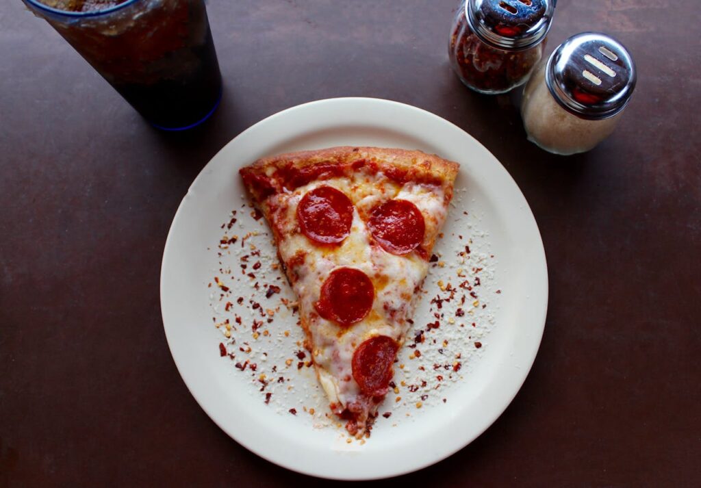 A mouthwatering slice of pepperoni pizza with cheese and spices, ideal for any meal.