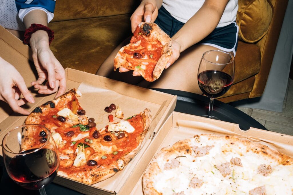 Young adults enjoying a pizza and wine night indoors.